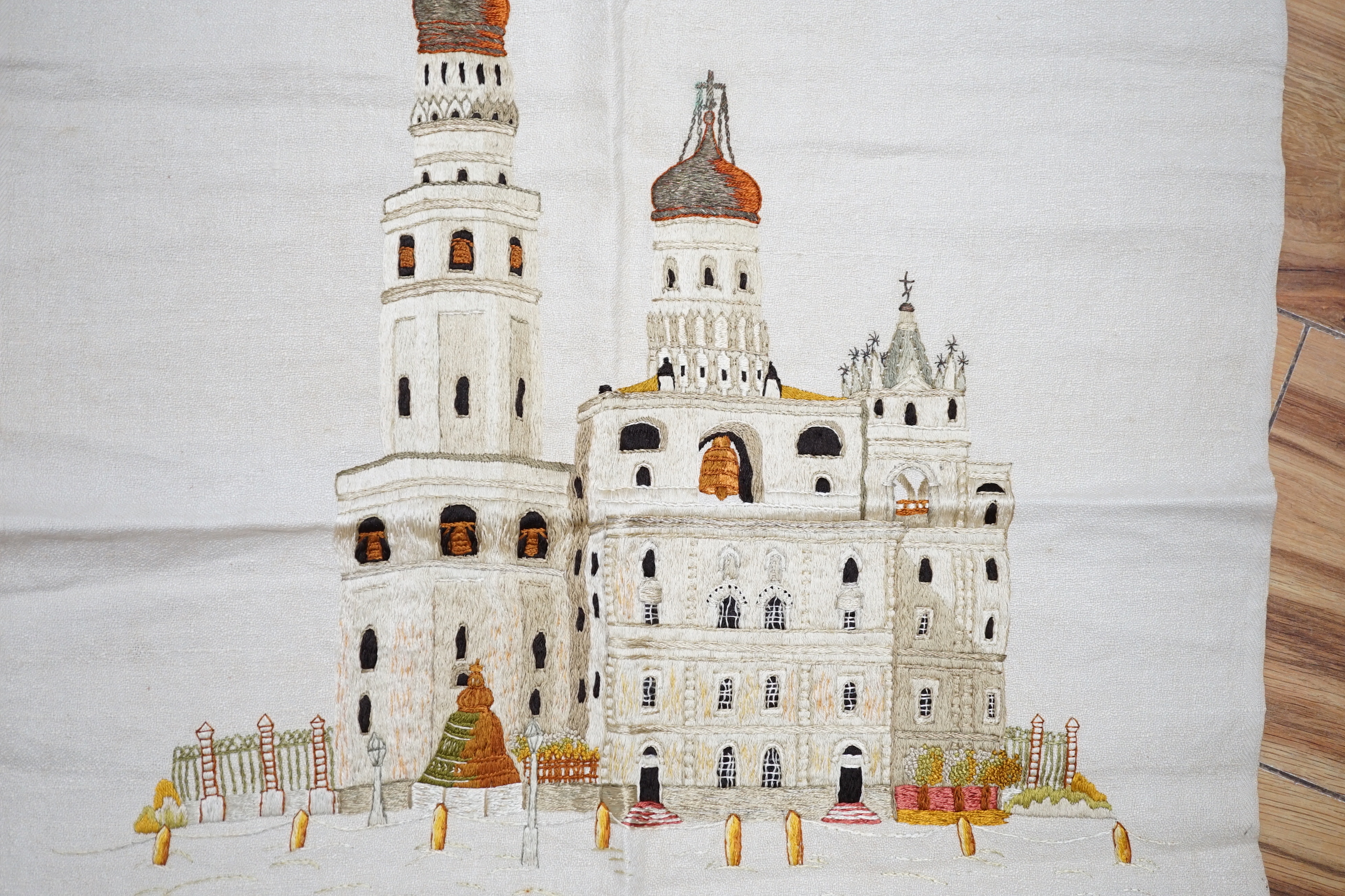 A Russian silk embroidery of a building with embroidered text below: translation ‘Ivan the Greats Belltower, The Kremlin’, 56cm high not including fringe